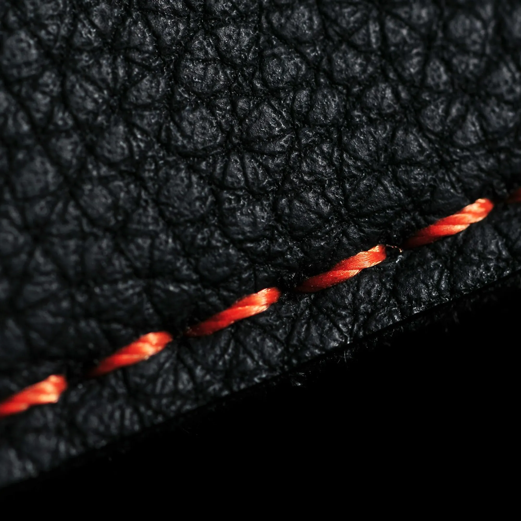 Close-up of a worker hand-stitching leather edges